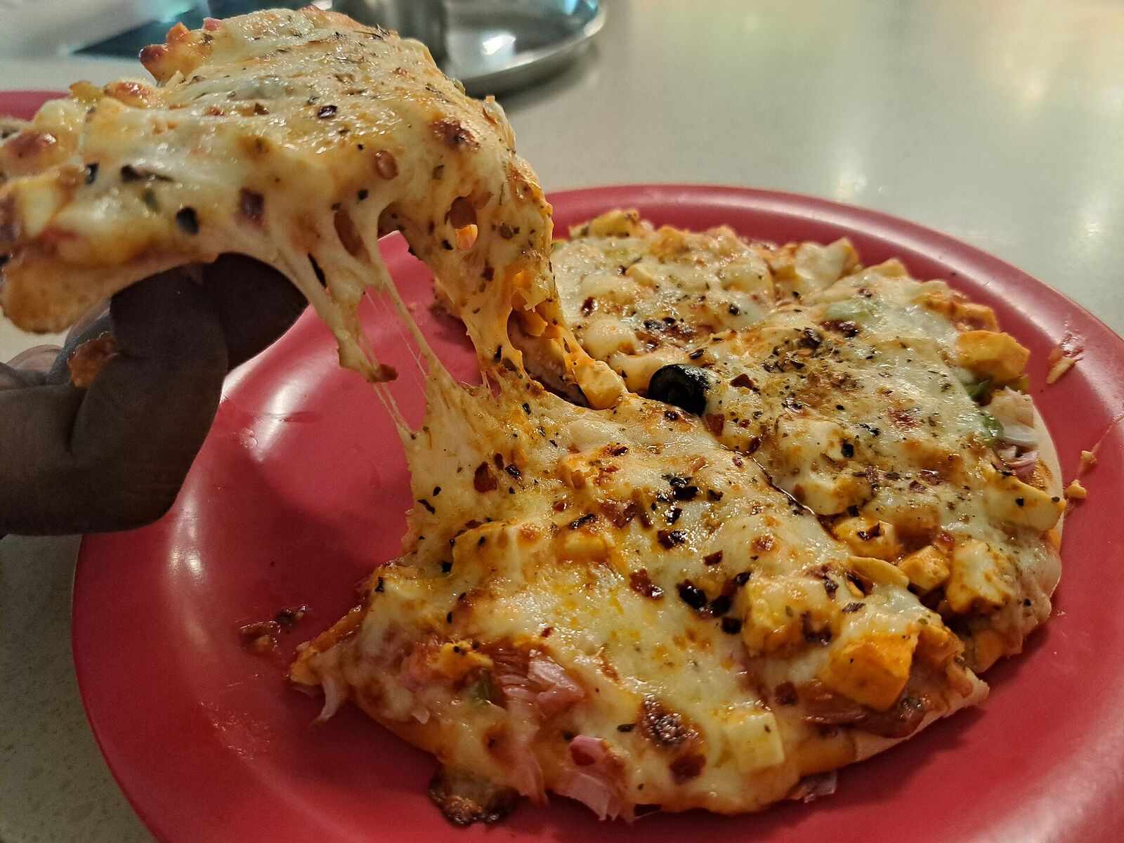 Slice lifted from a pizza with a long stretchy cheese pull