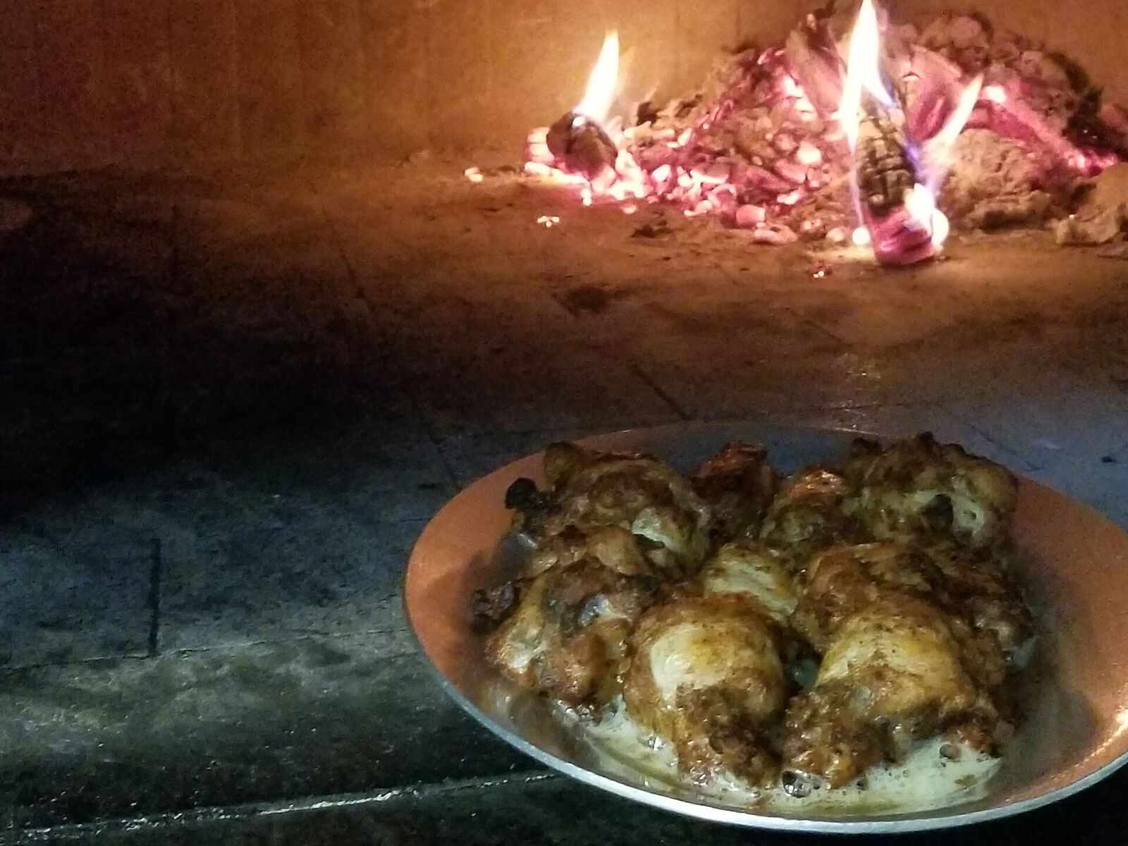 Plate of chicken wings in front of a glowing oven